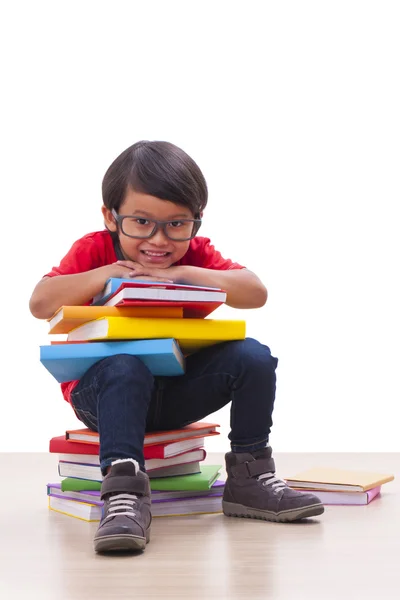 Garçon mignon assis et tenant des livres — Photo