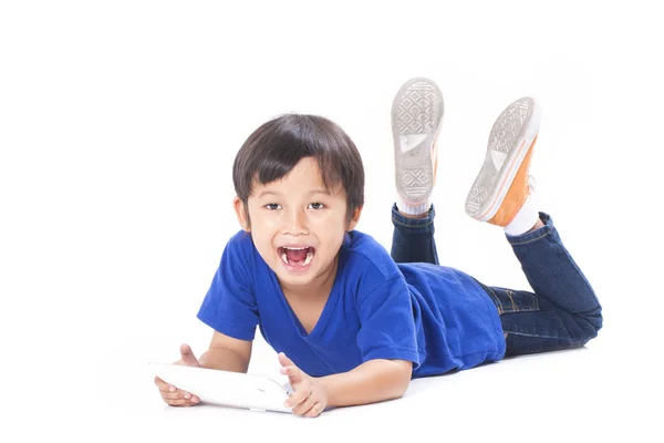 Carino ragazzo utilizzando tablet mentre sdraiato sul pavimento — Foto Stock