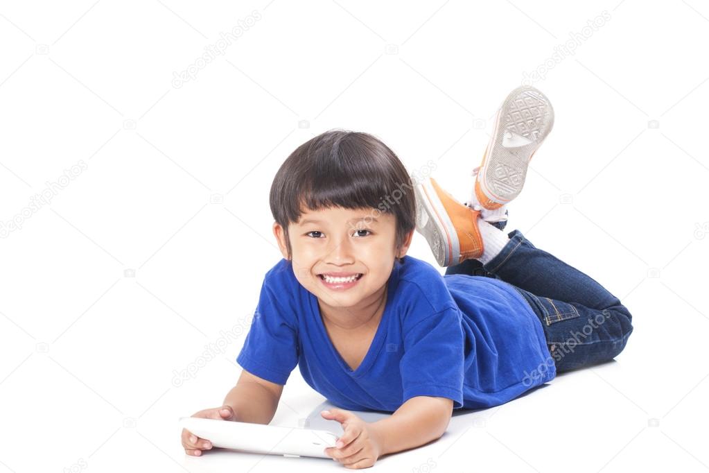 Cute boy using tablet while lying on the floor