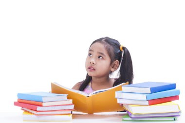 Küçük kız okuma ve kitap hakkında düşünüyor.