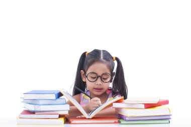 Küçük kız kitap okuyup yazıyor.