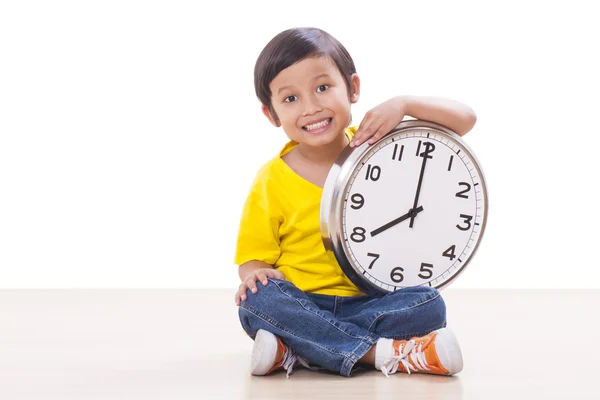 Schattige jongen zitten en houden grote klok — Stockfoto