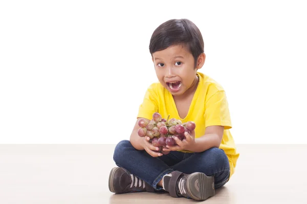 Carino ragazzo mangiare uva — Foto Stock