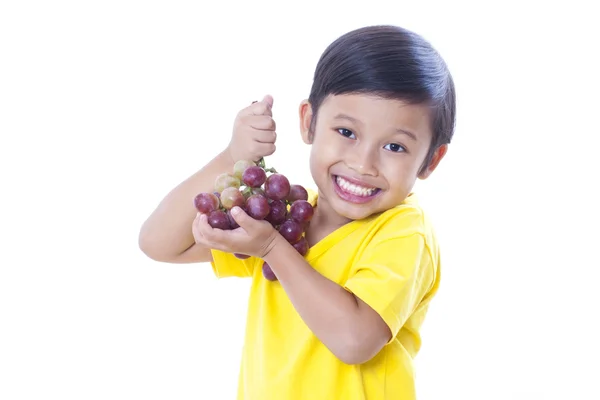 Милый мальчик ест виноград — стоковое фото