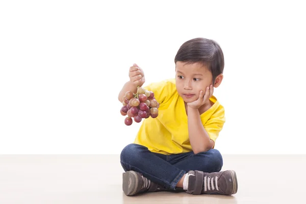 Mignon garçon manger des raisins — Photo