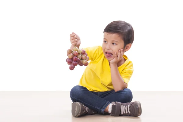 Carino ragazzo mangiare uva — Foto Stock