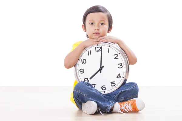 Cute boy sitting and holding big clock — Stock Photo, Image