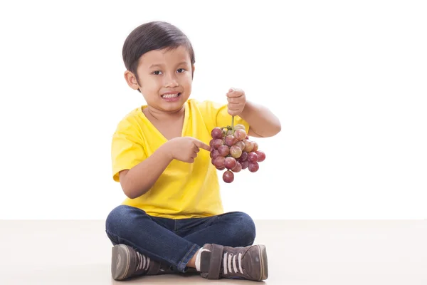 Rapaz bonito comendo uvas — Fotografia de Stock