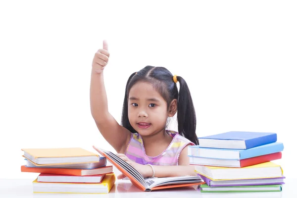 Klein meisje is het lezen van boek en tonen duim omhoog. — Stockfoto