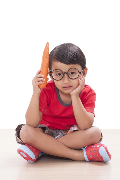 快乐的男孩，用一根胡萝卜。健康食品的概念. — 图库照片