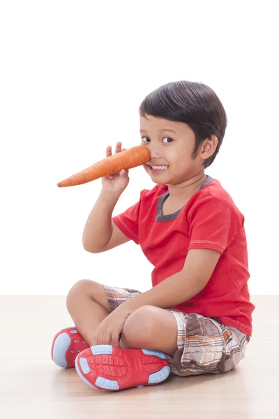Šťastný chlapec s mrkví. Koncept zdravé potraviny. — Stock fotografie