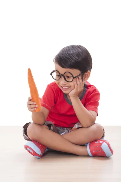 Ευτυχισμένο αγόρι με ένα καρότο. Έννοια της υγιεινής διατροφής. — Φωτογραφία Αρχείου