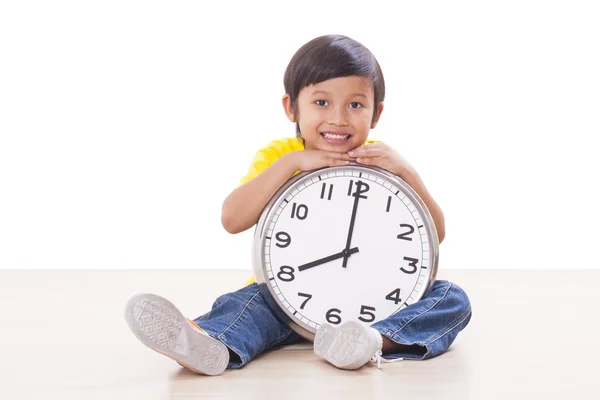 Cute boy sitting and holding big clock — Stock Photo, Image