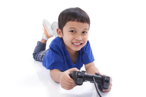 Pojke spelar videospel och liggande på golvet — Stockfoto