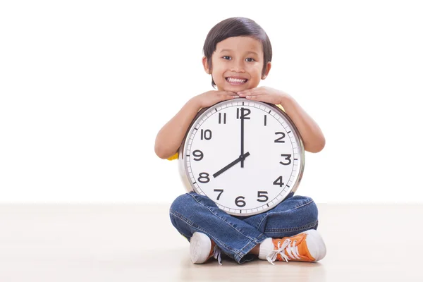 Schattige jongen zitten en houden grote klok — Stockfoto