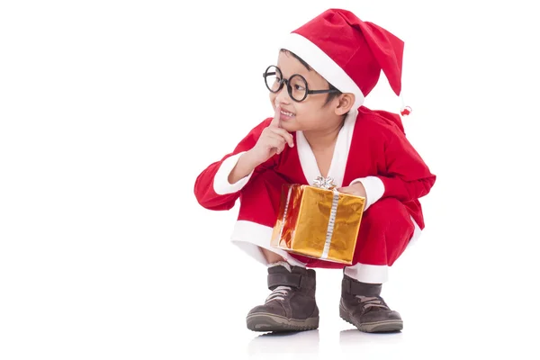 Kleine jongen dragen Santa Claus uniform met een cadeau — Stockfoto