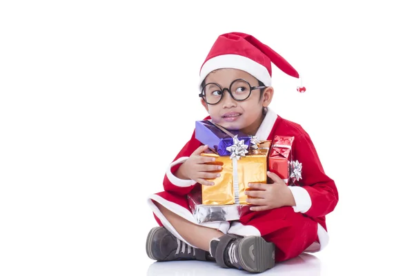 Kleine jongen dragen Santa Claus uniform met geschenken — Stockfoto