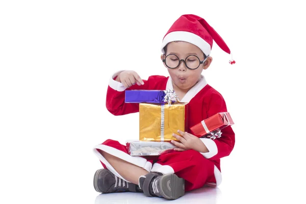 Little boy wearing Santa Claus uniform with gifts — Stock Photo, Image