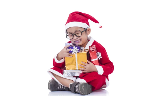 Little boy wearing Santa Claus uniform with gifts — Stock Photo, Image