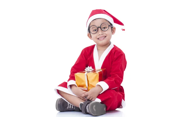 Little boy wearing Santa Claus uniform with gifts — Stock Photo, Image