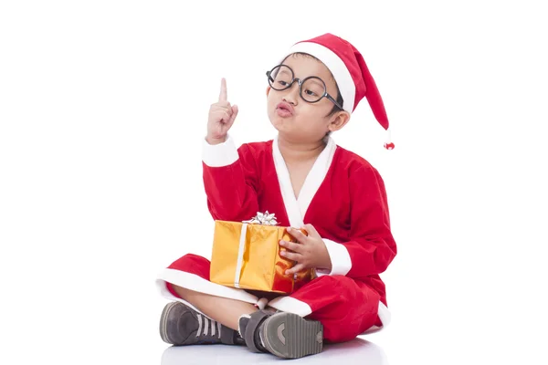 Kleine jongen dragen Santa Claus uniform met cadeau — Stockfoto