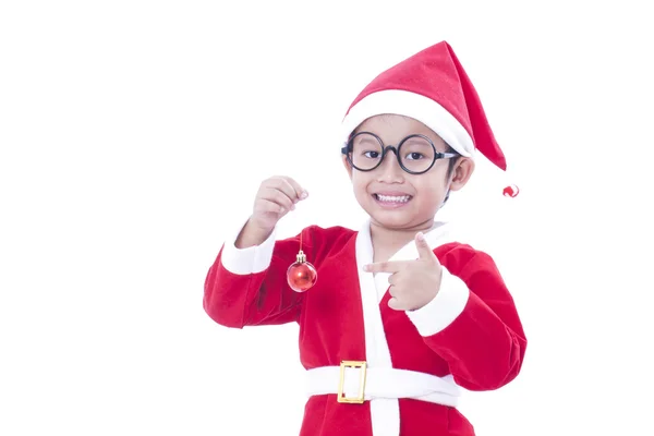 Gelukkige jongen dragen santa claus uniform en houden van rode Kerstmis bal — Stockfoto