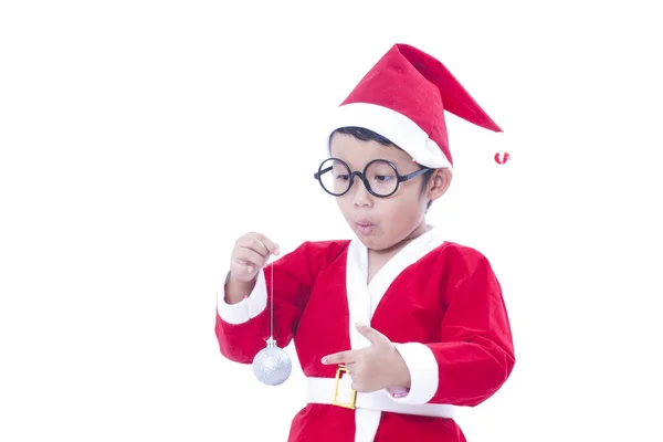 Gelukkige jongen dragen santa claus uniform en houden van witte Kerstmis bal — Stockfoto