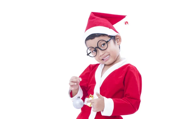 Happy boy wearing santa claus uniform and holding white christmas ball — Stock Photo, Image