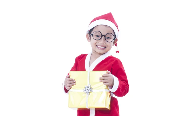 Little boy wearing Santa Claus uniform with a gift — Stock Photo, Image