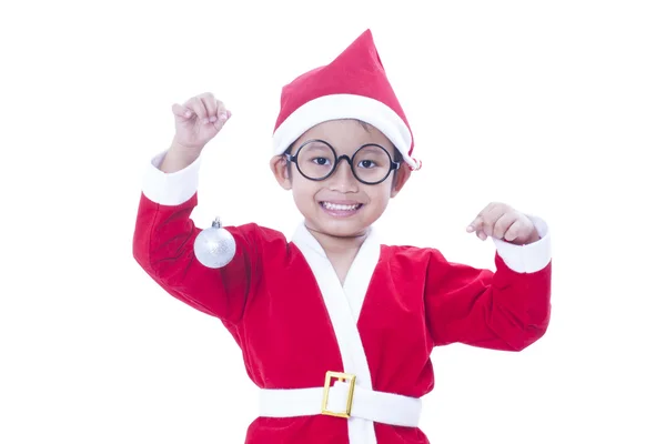 Gelukkige jongen dragen santa claus uniform en houden van witte Kerstmis bal — Stockfoto