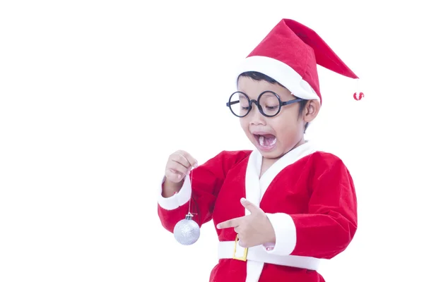 Gelukkige jongen dragen santa claus uniform en houden van witte Kerstmis bal — Stockfoto