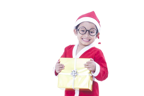 A kisfiú egy ajándékot Santa Claus egyenruhát visel — Stock Fotó
