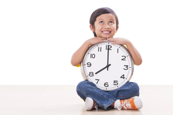 Schattige jongen zitten en houden grote klok — Stockfoto