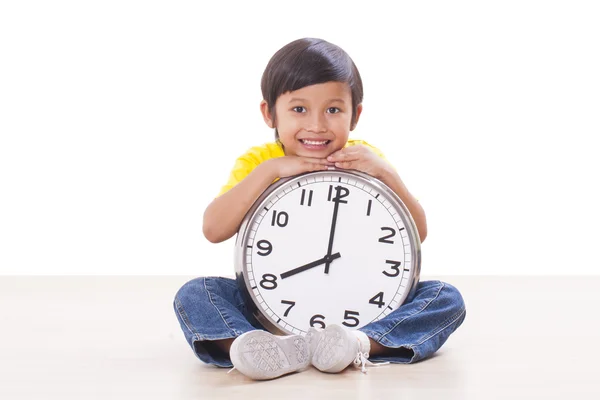 Söt pojke sitter och håller stora klocka — Stockfoto