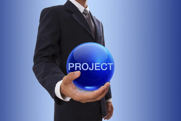 Geschäftsmann hält blaue Kristallkugel mit Projektwort in der Hand. — Stockfoto
