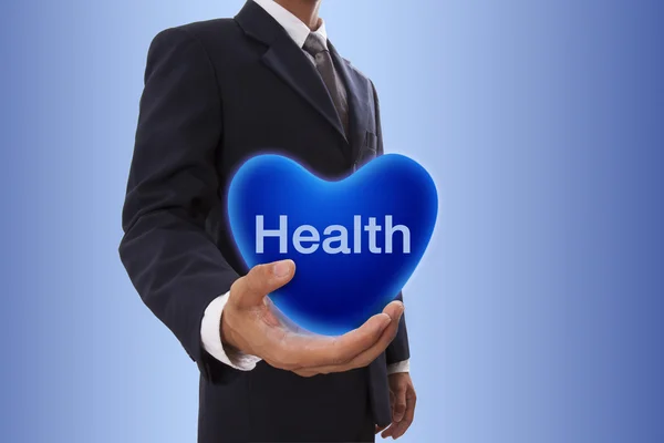 Uomo d'affari mano che tiene bolla di cuore blu con la parola di salute — Foto Stock