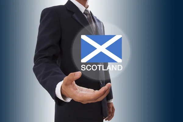 Empresario mano mostrando la bandera de Escocia — Foto de Stock