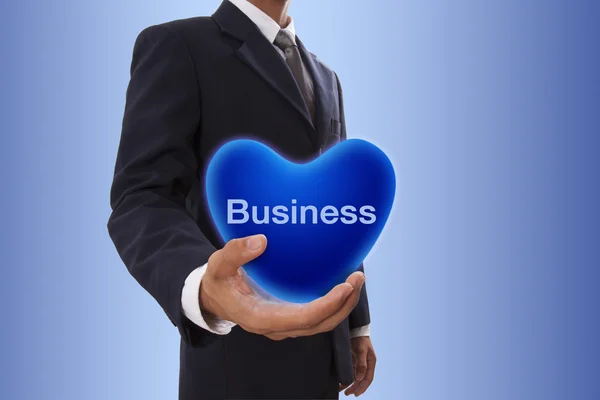 Biznesmen ręki trzymającej niebieskie serca bańka biznes słowem — Zdjęcie stockowe