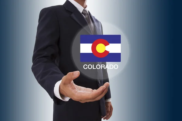 コロラド州の旗を表示中のビジネスマン手 — ストック写真
