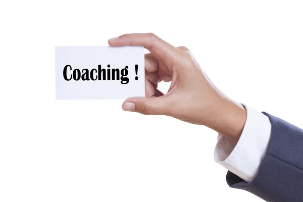 Zakenman met witte kaart met coaching woord op witte achtergrond. — Stockfoto