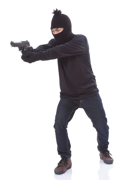 Man in a mask with a gun on a white background — Stock Photo, Image