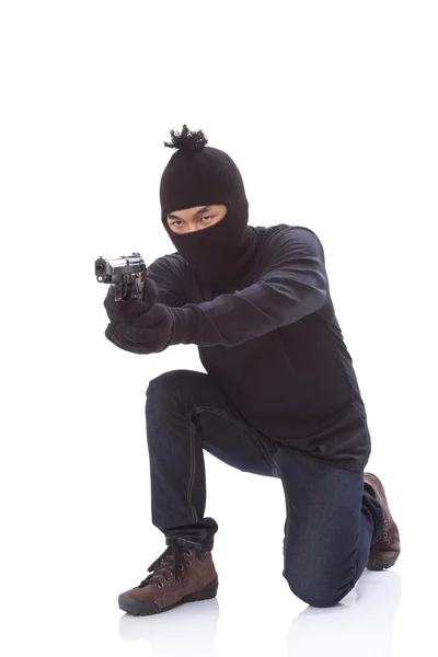 Άνθρωπος σε μια μάσκα με ένα πυροβόλο όπλο σε λευκό φόντο — Φωτογραφία Αρχείου