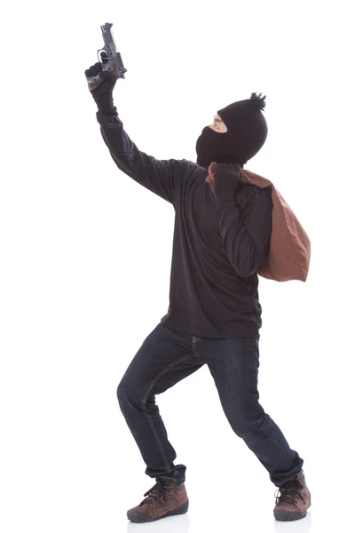 Bandit holding gun with bag on white background — Stock Photo, Image