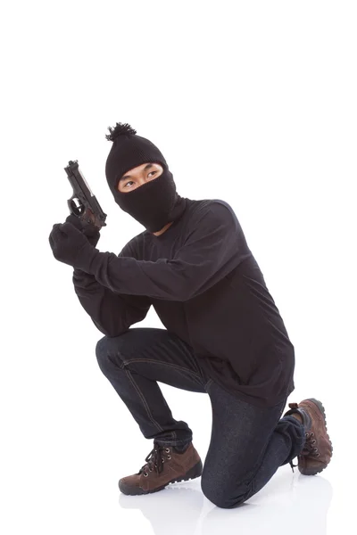 Человек в маске с пистолетом на белом фоне — стоковое фото
