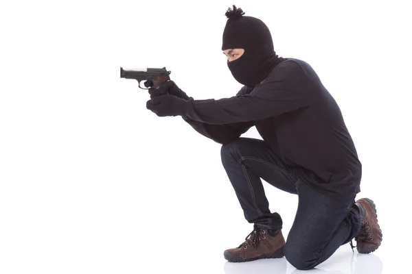 Uomo in maschera con una pistola su sfondo bianco — Foto Stock