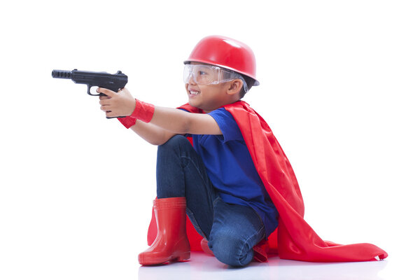 Child pretending to be a superhero with toy gun on white background