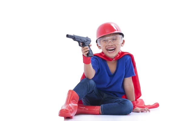 Bambino fingendo di essere un supereroe con pistola giocattolo su sfondo bianco — Foto Stock