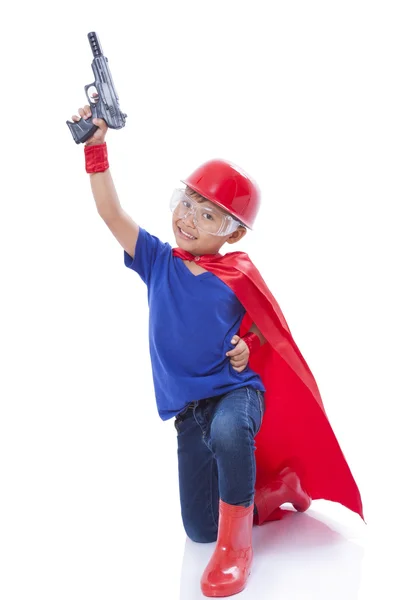 Niño fingiendo ser un superhéroe con pistola de juguete sobre fondo blanco — Foto de Stock