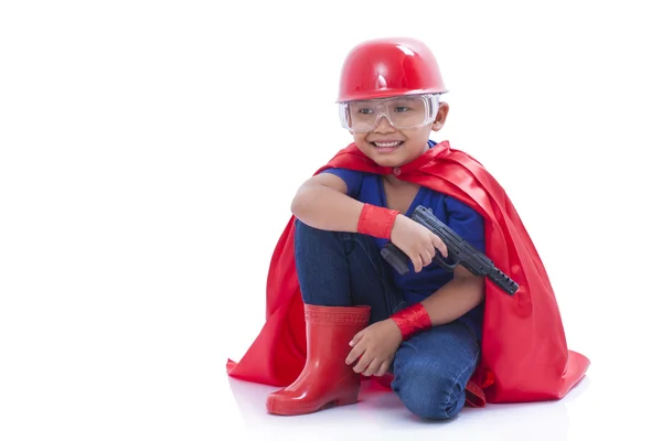 Bambino fingendo di essere un supereroe con pistola giocattolo su sfondo bianco — Foto Stock