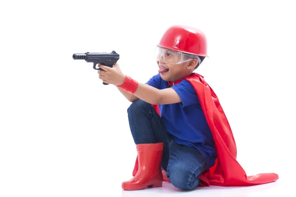 Criança fingindo ser um super-herói com arma de brinquedo no fundo branco — Fotografia de Stock